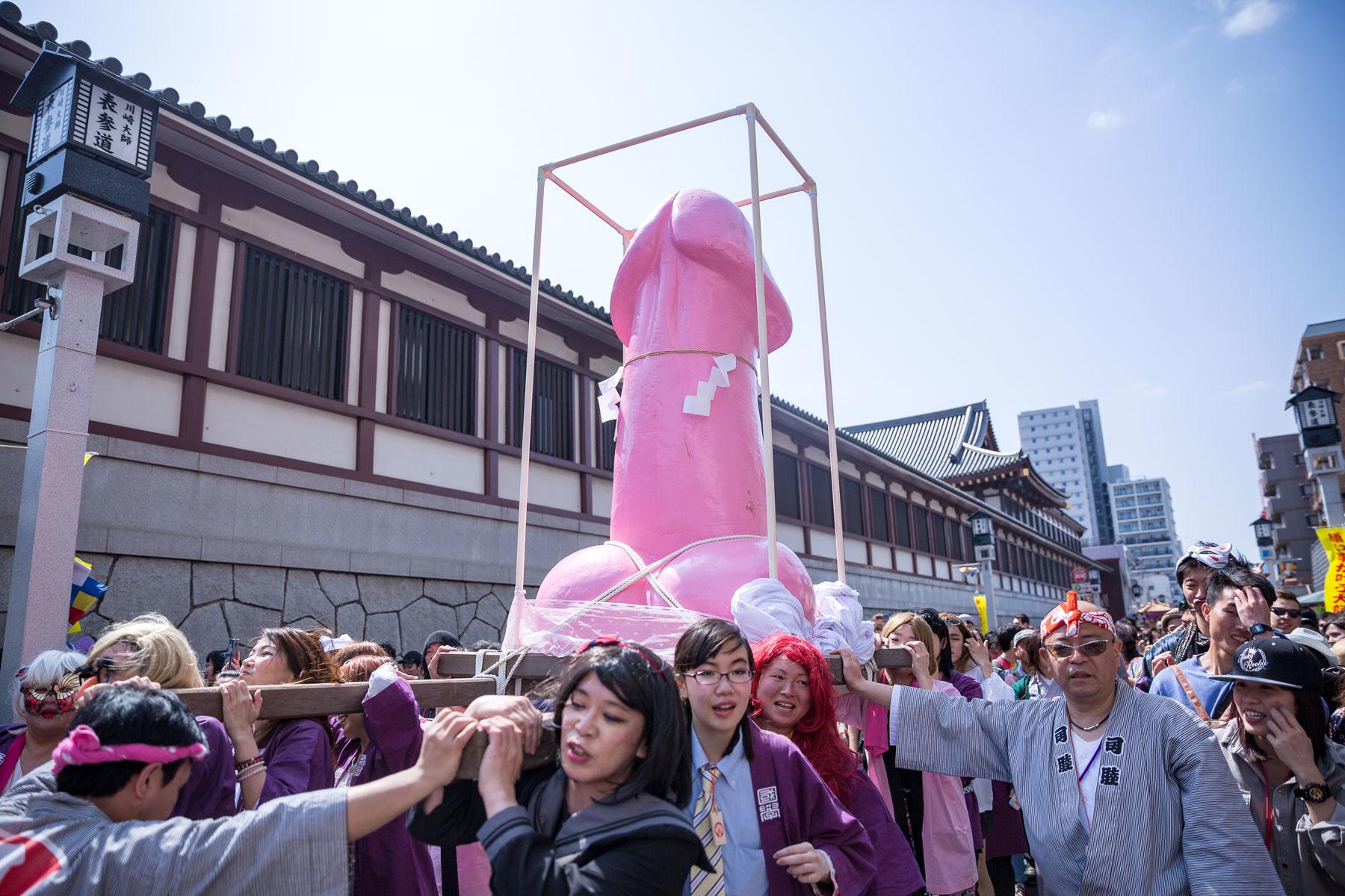 A parade of people holding a giant pink penis
