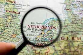 A magnifying glass magnifying Netherlands which is written on a globe