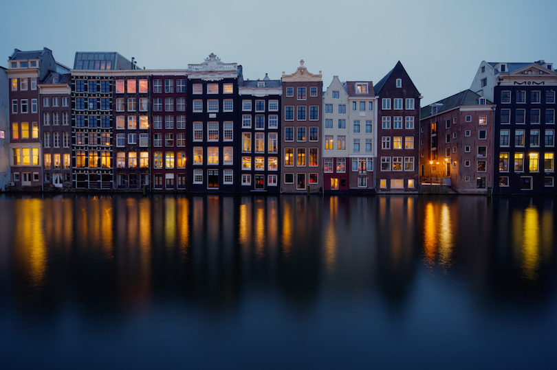 Amsterdam buildings in front of a river in night in Netherlands