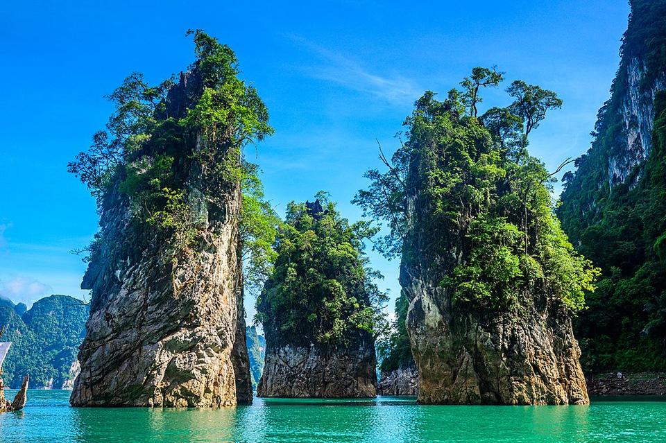 Two giant stones/mountains covered with plants in the middle of Thailand beach sea