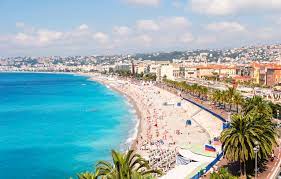 The French Riviera beach with trees which surrounded by houses and buildings