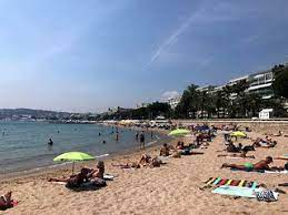 The beach at Plage Zamenhoff is crowded with tourists, visitors, and locals sunbathing