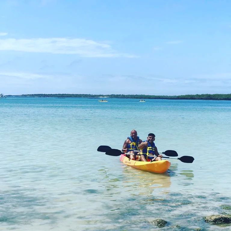 Two men canoeing at the shallow part of the Tortuga Bay in the Galapagos Island