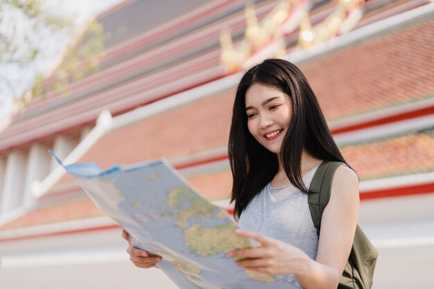 Asian woman wearing blue shirt holding Thailand map in Bangkok, Thailand
