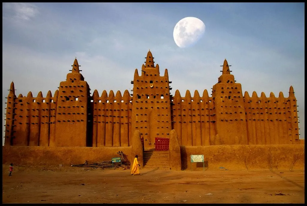 Djenné's Great Mosque with a person walking while looking at it