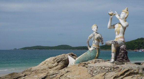 Two white ceramic statues on the stone on Koh Samet beach