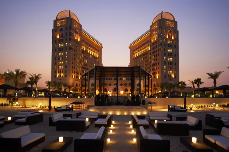 St. Regis Doha Hotel At The Back Of A Sandy Area With Set Of Black And White Sofas