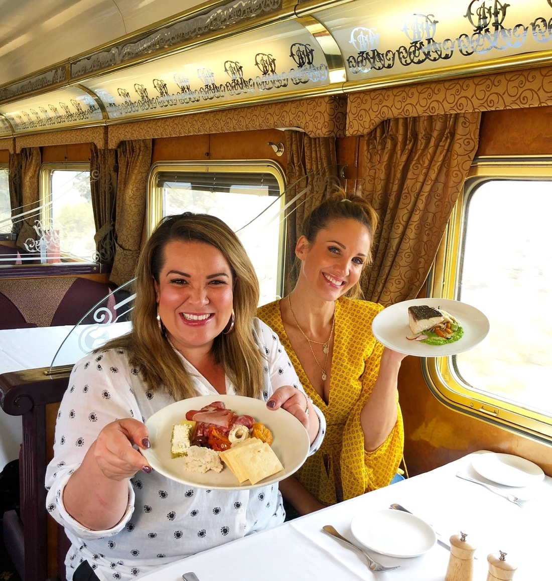 Two Women Showcasing The Food Served At The Ghan