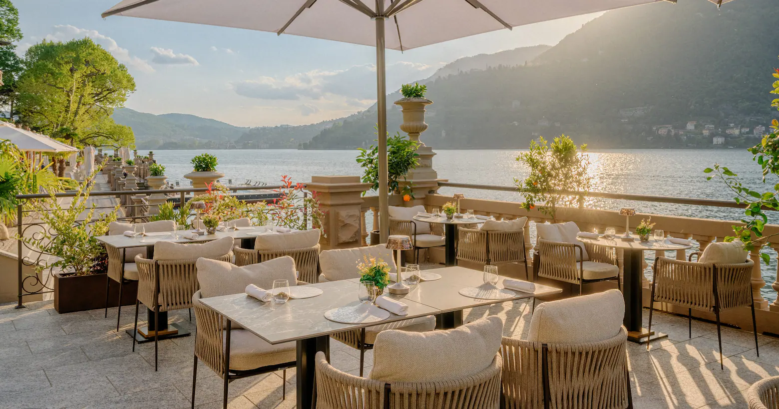 Some Tables Under An Umbrella At Lake Como