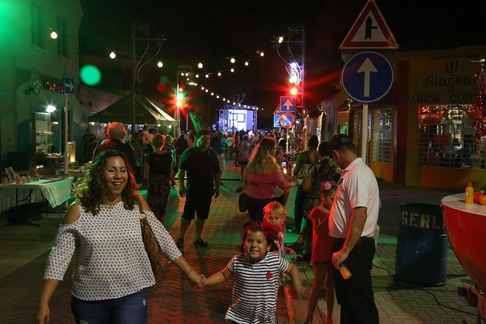 San Nicolas Aruba street with people walking around during night time