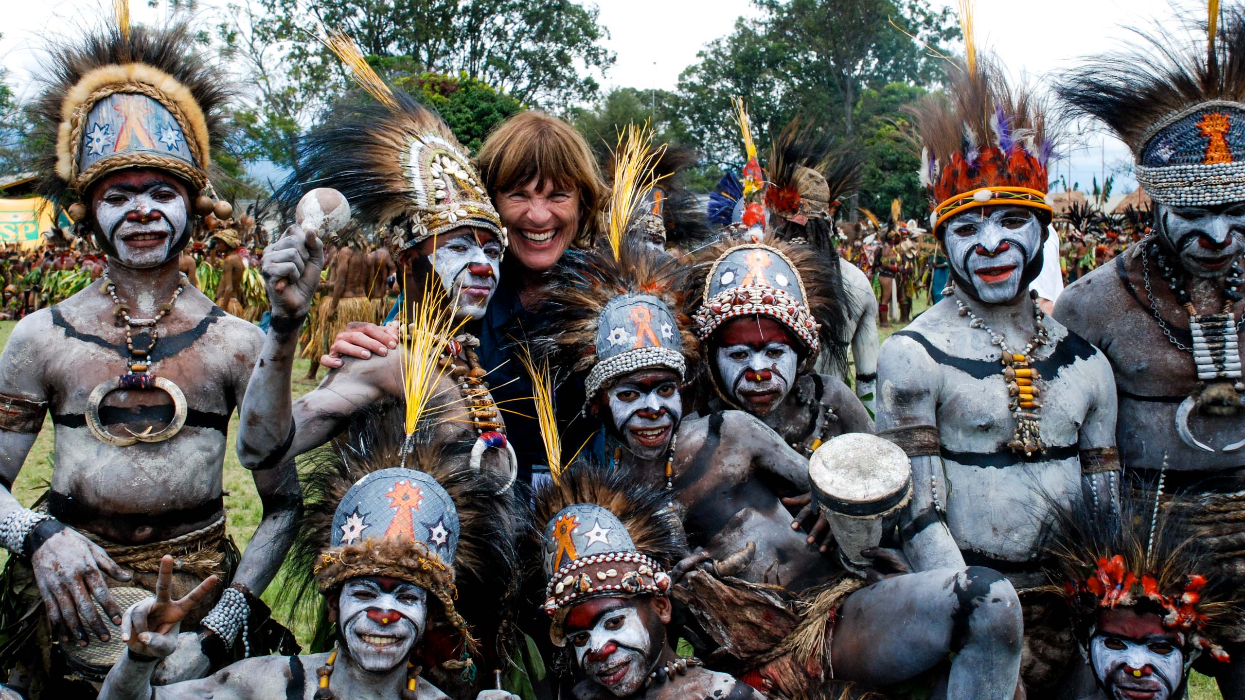 A foreigner posing on camera with some locals in Papua New Guinea