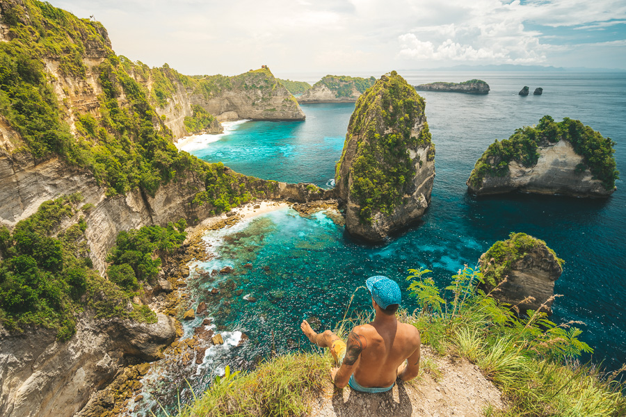 A tourist sitting at the edge of the cliff in Nusa Penida