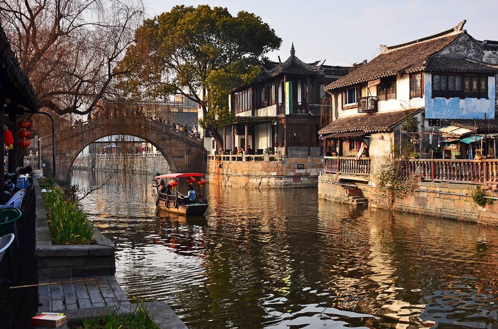 A woman riding a boat on a river in Fengjing Ancient Town