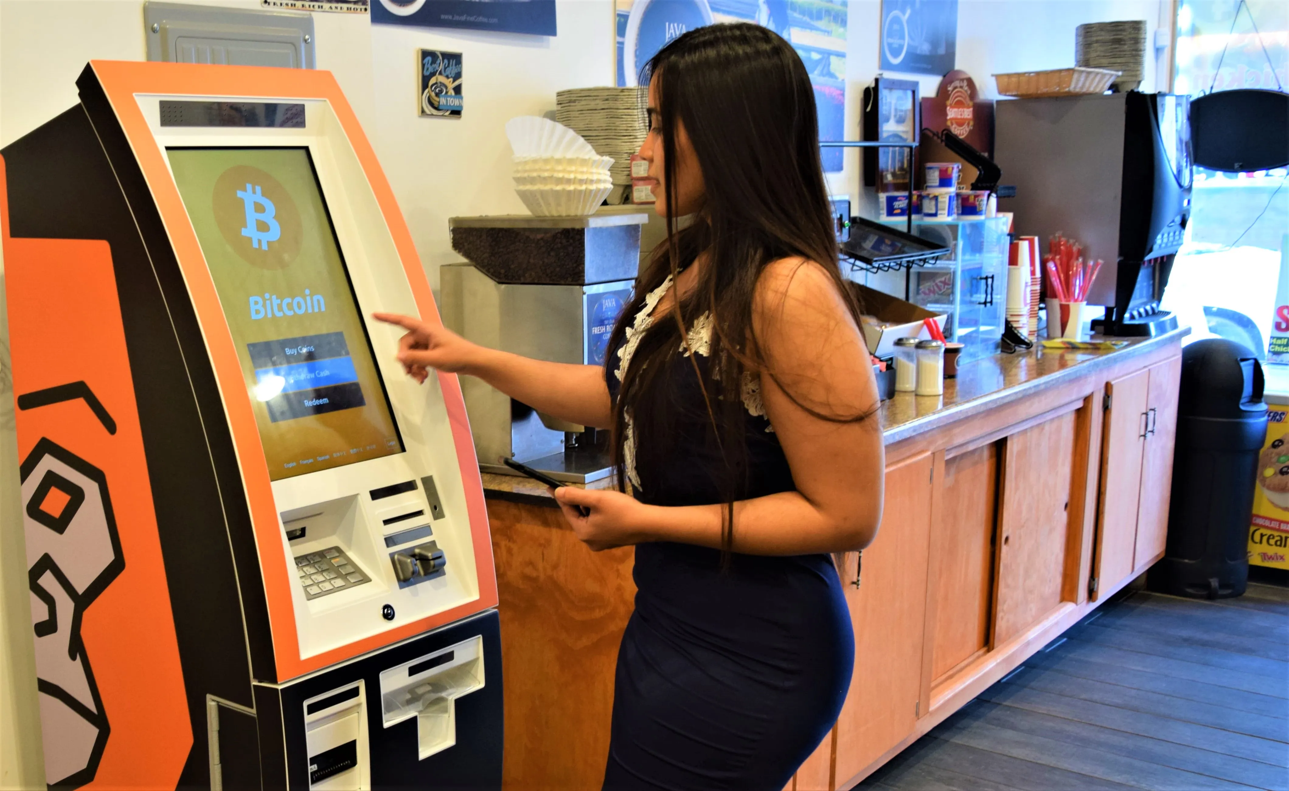 A woman using a bitcoin payment machine in Vancouver