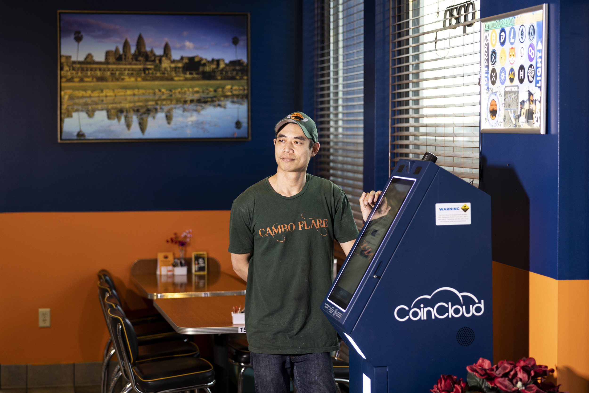 A man beside a crypto payment machine in a restaurant