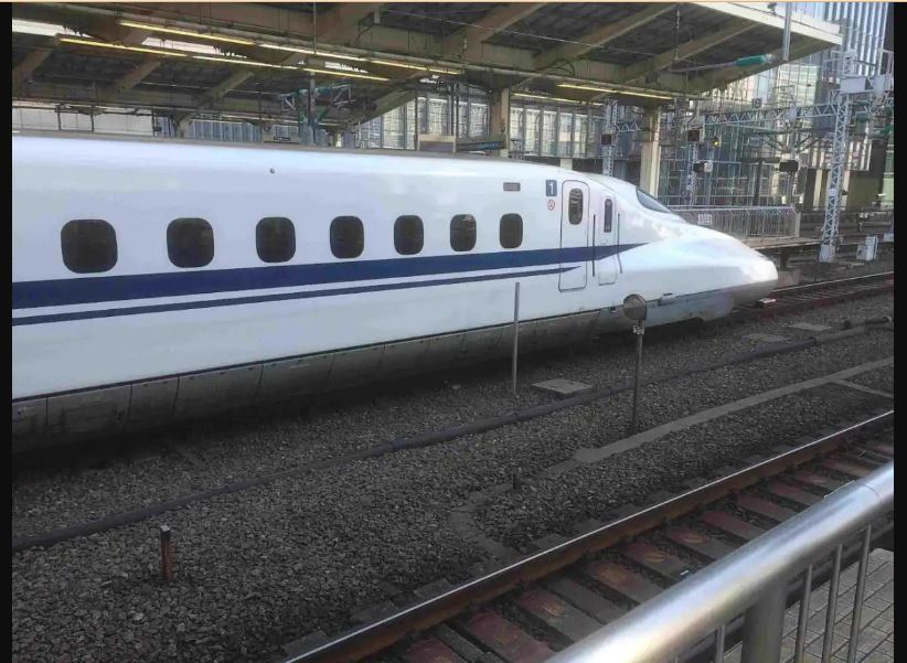 A white bullet train waiting on the railway