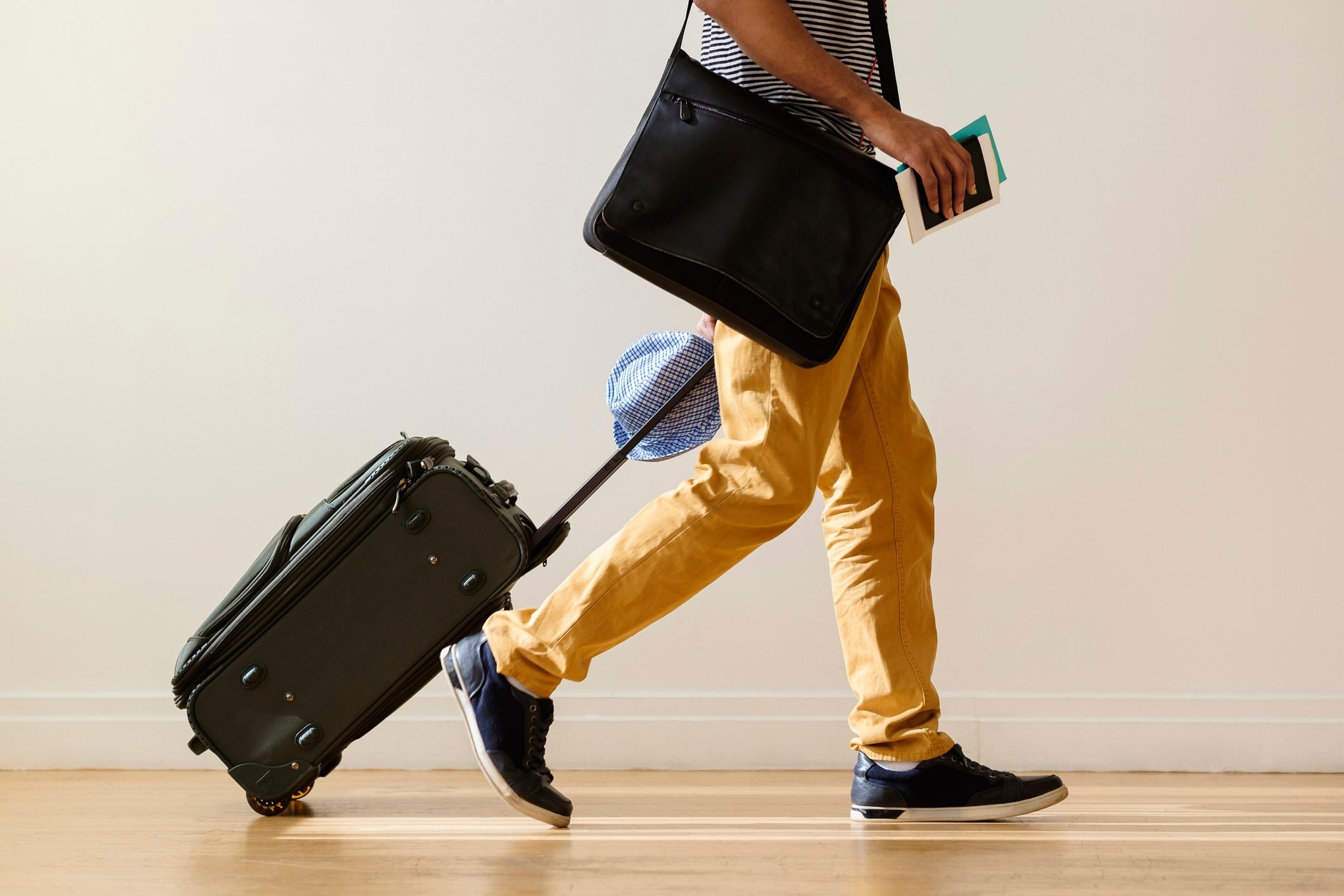 A man wearing a mustard colored jeans with a luggage