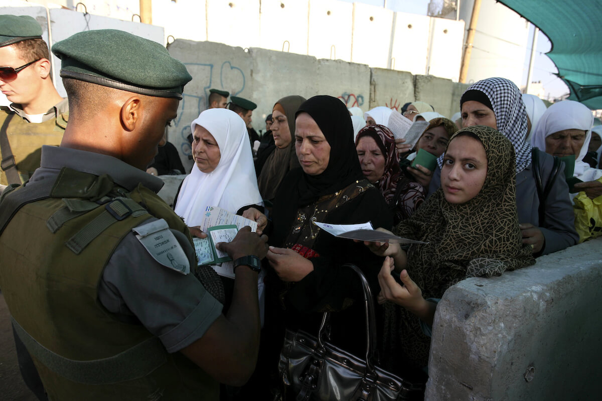 A crowd of Palestinian women wait to pass the first of several checkpoints at the Galandia checkpoint